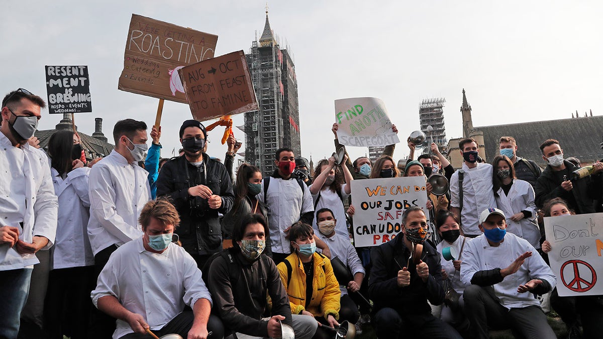 Hospitality workers protest in Parliament Square in London, Monday, Oct. 19, 2020. Hospitality workers are demonstrating outside Parliament against tougher coronavirus restrictions and the amount of financial support given by the government to the industry.(AP Photo/Frank Augstein)