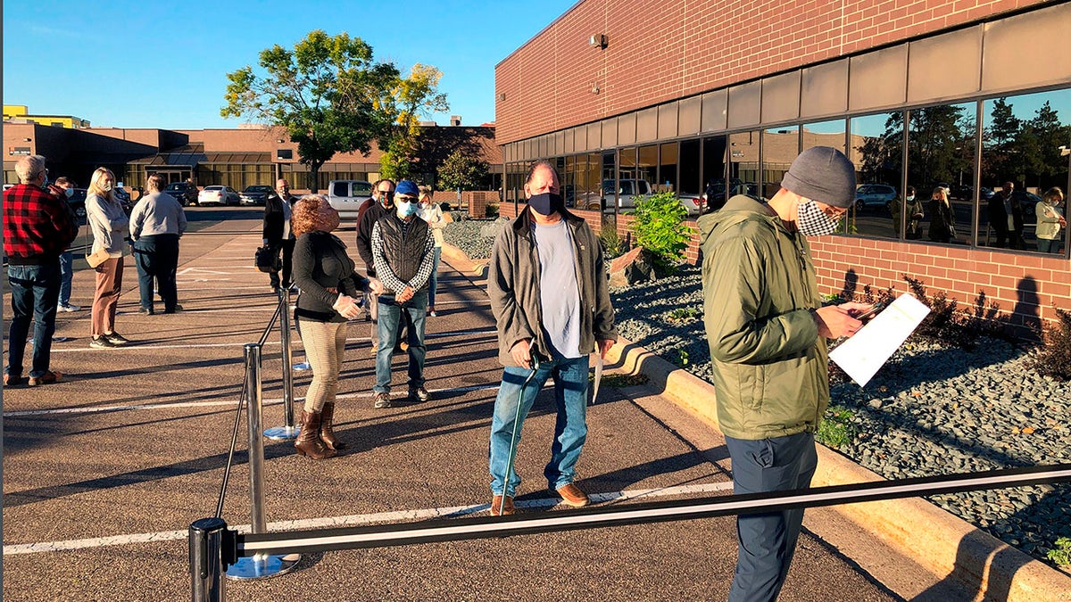 In this Sept. 8, 2020 file photo voters line up outside of the Minneapolis early voting center as Minnesota opened early voting for the general election. (AP Photo/Steve Karnowski, File)