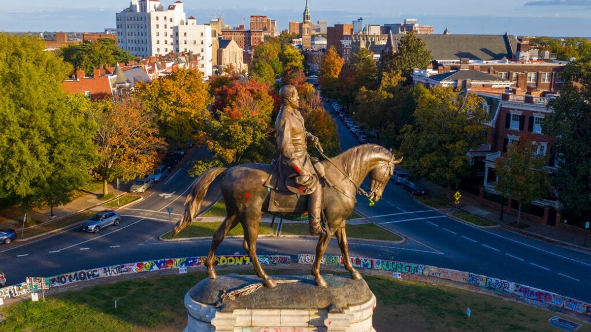 The afternoon sun illuminates the statue of Confederate General Robert E. Lee on Monument Ave in Richmond, Va., Monday, Oct. 19, 2020. A Richmond judge heard arguments in a lawsuit over the Governors' order to remove the statue. (AP Photo/Steve Helber)