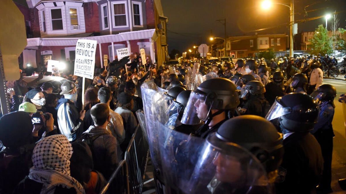 Protesters face off with police during a demonstration Tuesday, Oct. 27, 2020, in Philadelphia. (AP Photo/Michael Perez)