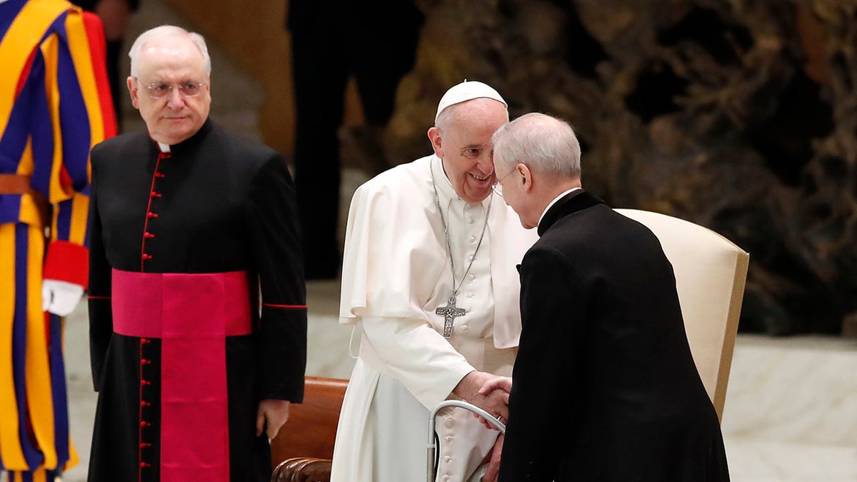 Pope Francis shakes hands with Monsignor Luis Maria Rodrigo Ewart as he arrives in the Paul VI Hall at the Vatican for his weekly general audience, Wednesday, Oct. 28, 2020. (AP Photo/Alessandra Tarantino)