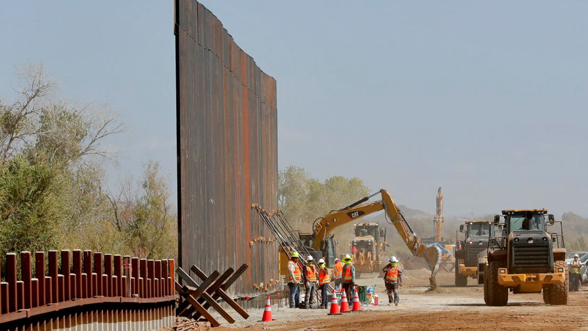 Contractors erect a section of border wall, replacing smaller fortifications, Tuesday, Sept. 10, 2019, along the Colorado River in Yuma, Ariz. (AP Photo/Matt York)