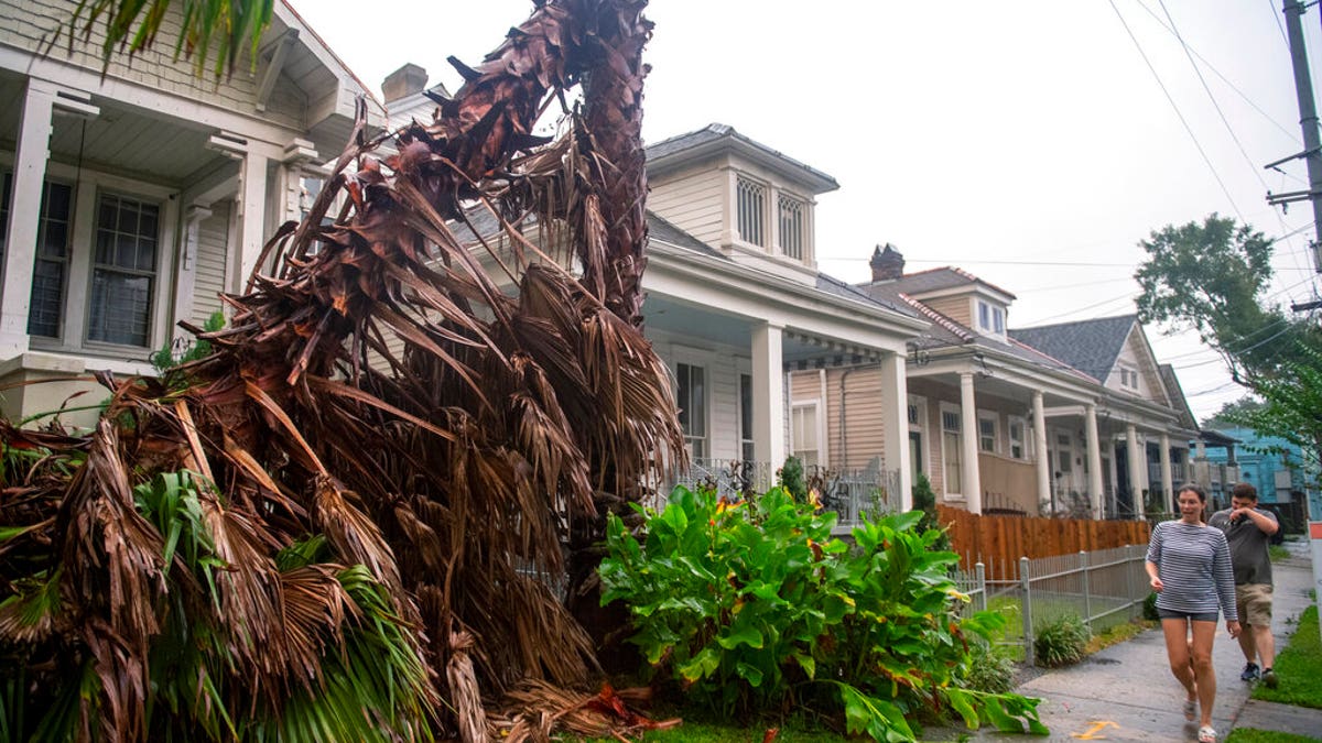 People walk along a sidewalk in New Orleans as the outer eye wall of Hurricane Zeta passed by the city, Oct. 28. (Chris Granger/The Times-Picayune/The New Orleans Advocate via AP)