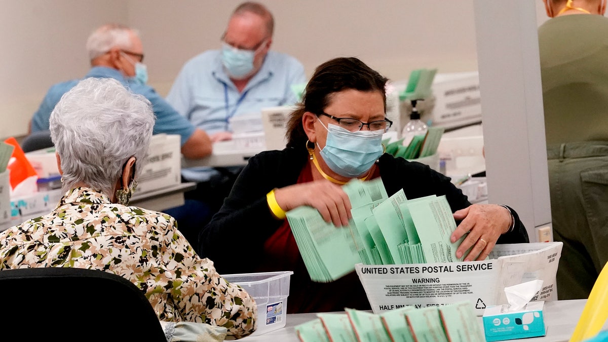 Election workers sort ballots Wednesday, Oct. 21, 2020, at the Maricopa County Recorder's Office in Phoenix. (AP Photo/Matt York)