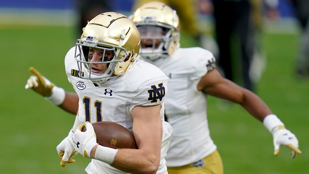 Notre Dame wide receiver Ben Skowronek, left, heads to the end zone as teammate Avery Davis (3) cheers him on after making a catch against Pittsburgh during the first half of an NCAA college football game, Saturday, Oct. 24, 2020, in Pittsburgh. (AP Photo/Keith Srakocic)