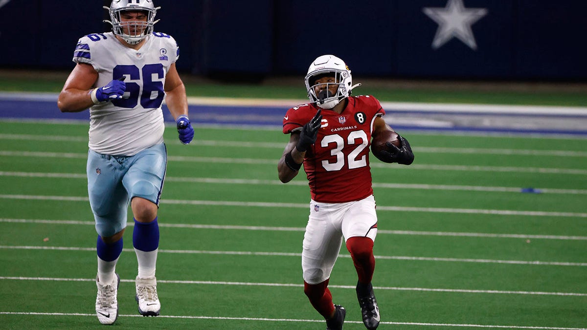 Dallas Cowboys guard Connor McGovern (66) gives chase as Arizona Cardinals' Budda Baker (32) returns an Andy Dalton (14) interception in the second half of an NFL football game in Arlington, Texas, Monday, Oct. 19, 2020. (AP Photo/Ron Jenkins)