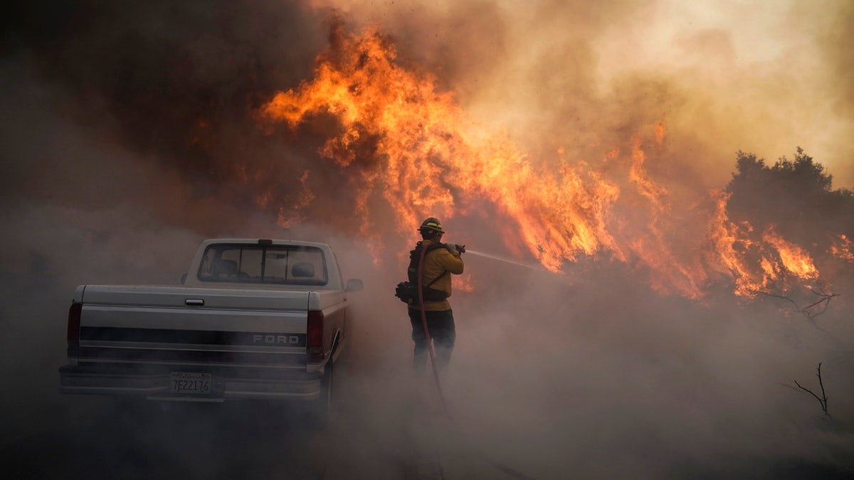 Firefighter Raymond Vasquez battles the Silverado Fire Monday, Oct. 26, 2020, in Irvine, Calif.