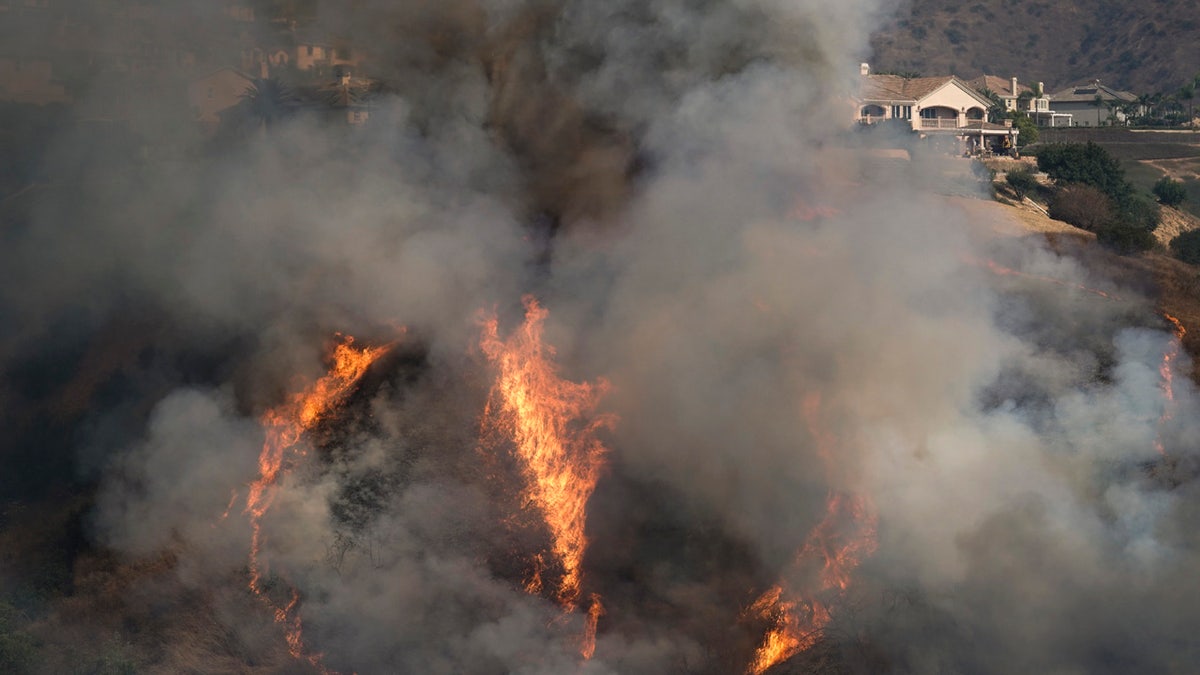 The Blue Ridge Fire burns near homes Tuesday, Oct. 27, 2020, in Yorba Linda, Calif.