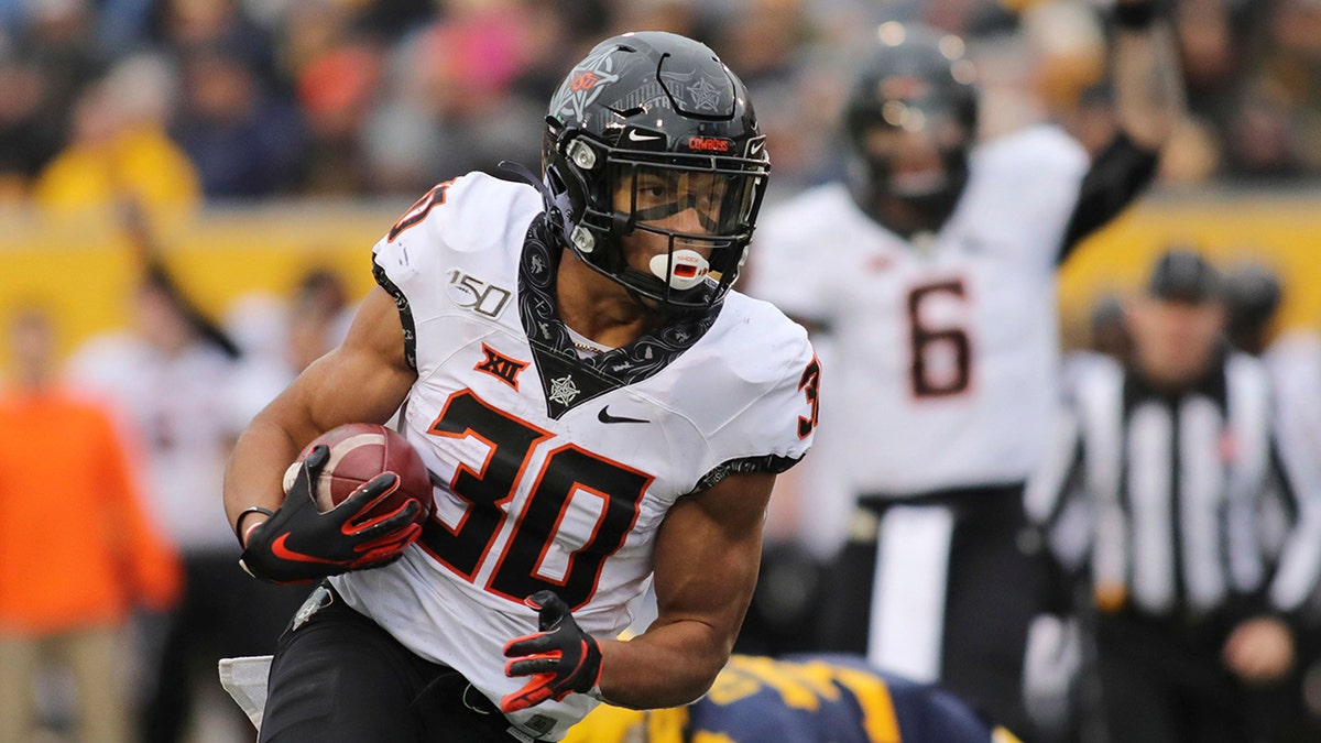 FILE - In this Saturday, Nov. 23, 2019 file photo, Oklahoma State's Chuba Hubbard (30) carries the ball during the second quarter of an NCAA college football game against West Virginia in Morgantown, W.Va. (AP Photo/Chris Jackson, File)