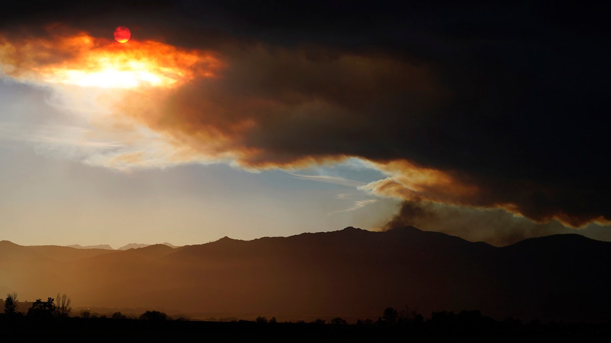 The smoke plume obscures the sun as smoke tops a ridge in this view from 75th Street as several wildfires burn in the state Wednesday, Oct. 21, 2020, in Niwot, Colo. 