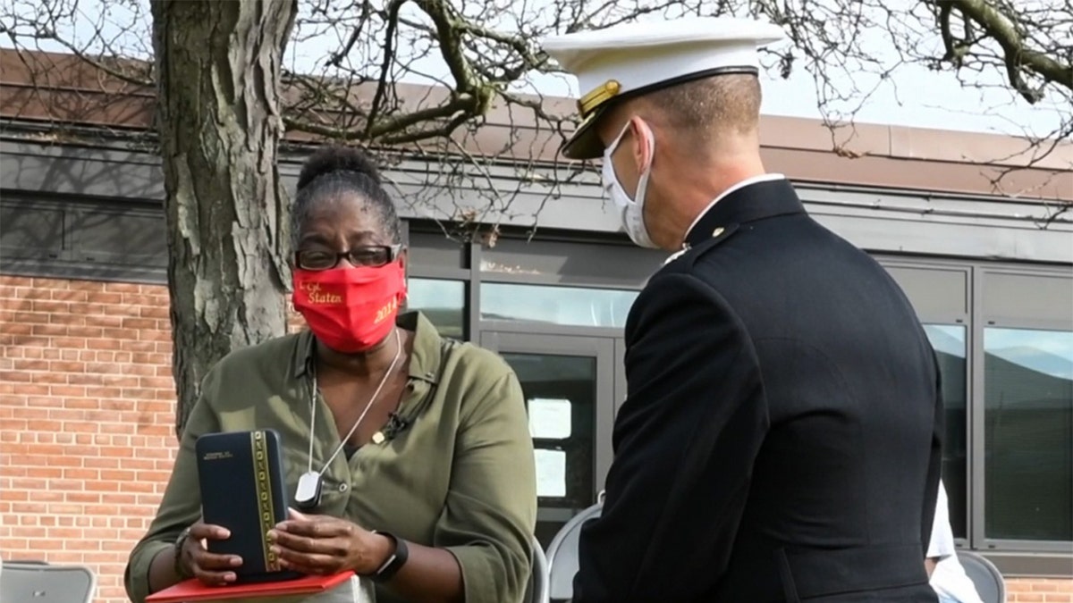 .A U.S. Marine Corps Major with 4th Combat Engineer Battalion presents Lance Cpl. Corey Staten’s mother, Nancy Staten, the Navy and Marine Corps Medal during an award ceremony in Baltimore.