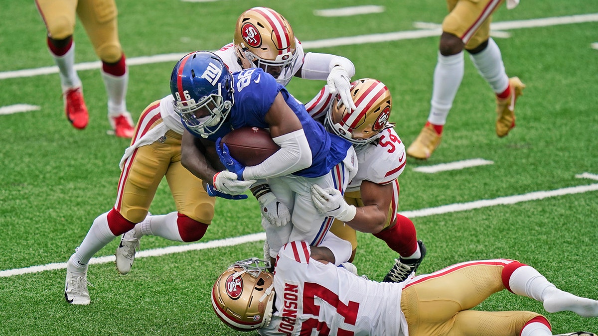 San Francisco 49ers defenders bring down New York Giants' Darius Slayton, center, during the second half of an NFL football game, Sunday, Sept. 27, 2020, in East Rutherford, N.J. (AP Photo/Corey Sipkin)