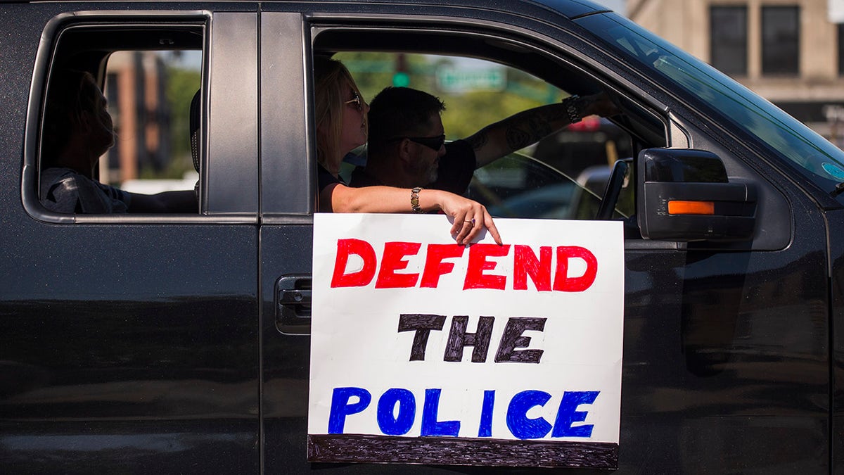 BLOOMINGTON, INDIANA, UNITED STATES - 2020/08/08: A protester holds a sign that says Defend the Police as a pro-police protesters passes through downtown Bloomington during a "Defend the Police," event in support of the police and to protest against defunding the police. (Photo by Jeremy Hogan/SOPA Images/LightRocket via Getty Images)