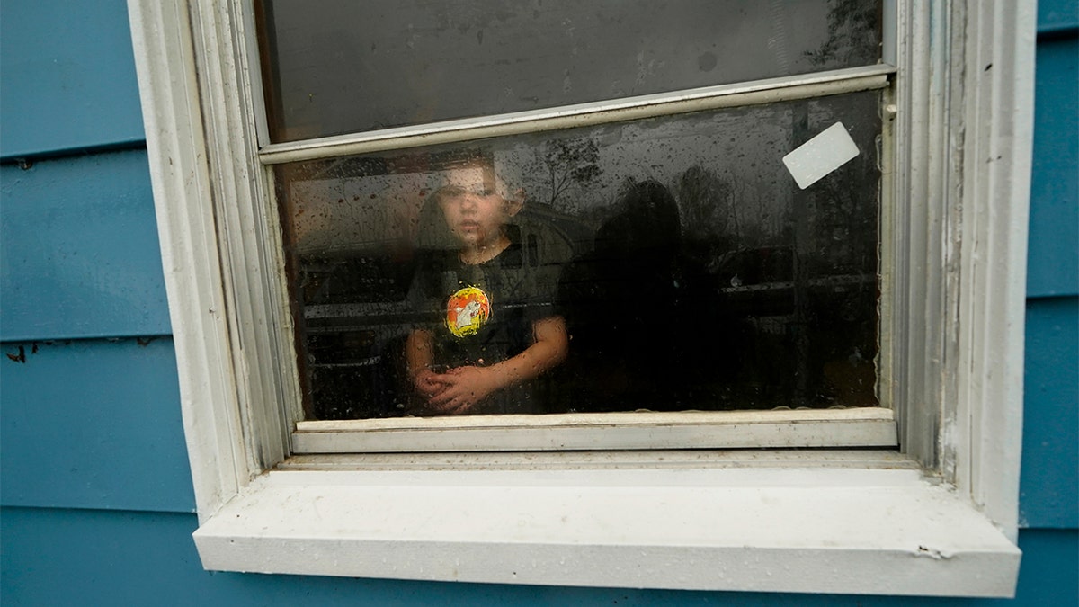 Hunter Daniel, 3, looks out the window of his uncle's house, to which his family temporarily relocated to ride out Hurricane Delta on Oct. 9. (AP Photo/Gerald Herbert)