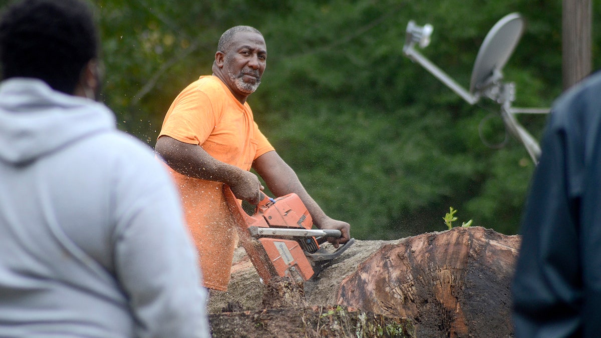 Carey Blackmon cuts an oak tree after it fell on the home of Larry Veal, Saturday, Oct. 10, 2020, in Gloster, Miss., during Hurricane Delta.