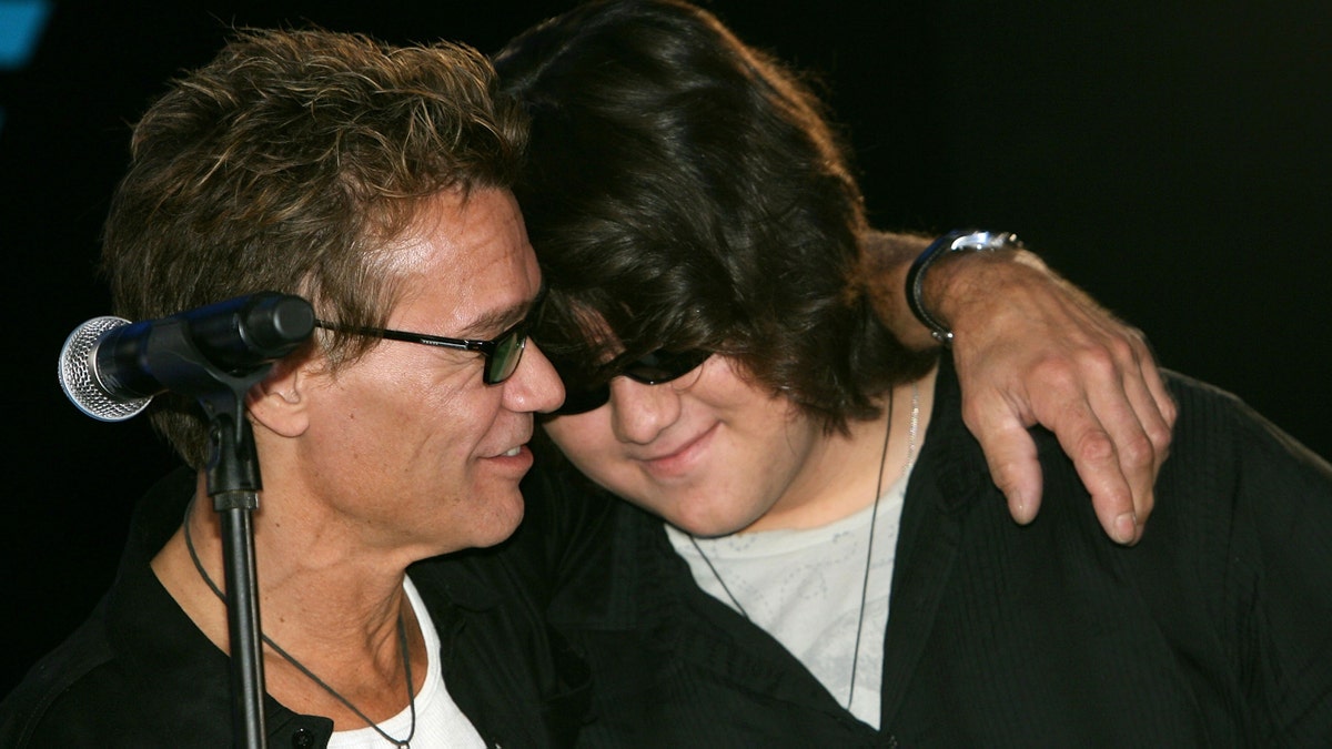 Eddie Van Halen (L) and son Wolfgang hug at the Van Halen press conference announcing their new tour at the Four Seasons Hotel on August 13, 2007, in Los Angeles, California.