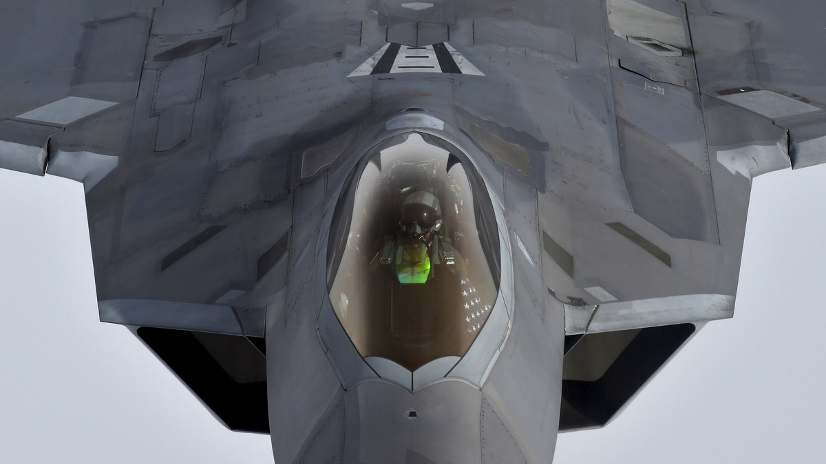 A pilot looks up from a U.S. F-22 Raptor fighter as it prepares to refuel in midair with a KC-135 refuelling plane over European airspace during a flight to Britain from Mihail Kogalniceanu air base in Romania April 25, 2016 - file photo.