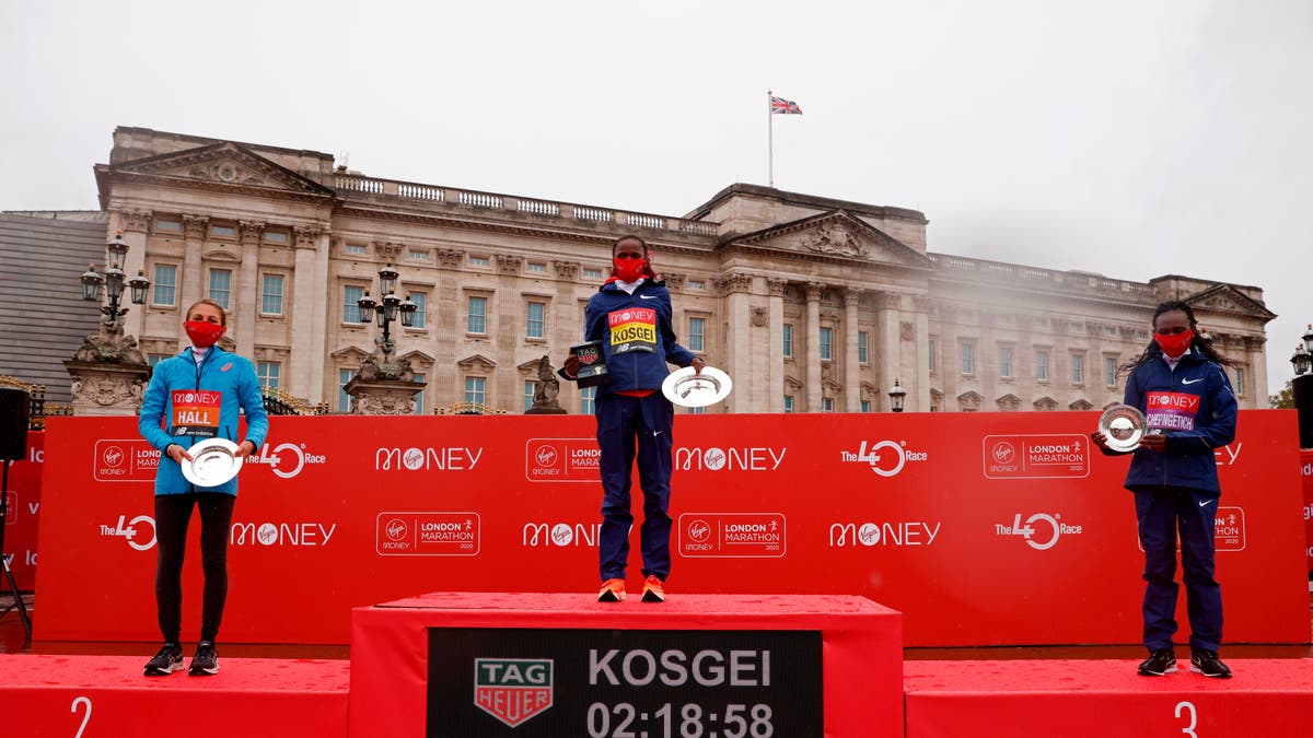 US runner Sara Hall (L), winner, Kenya's Brigid Kosgei (C) and third place Kenya's Ruth Chepngetich (R) pose for a photograph with their trophies in front of Buckingham Palace after the women's race of the 2020 London Marathon on October 4. (JOHN SIBLEY/POOL/AFP via Getty Images)