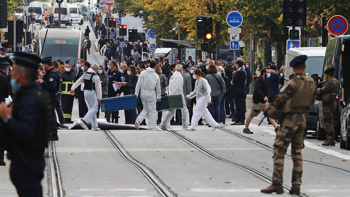 Forensics officers deploy stretchers at the site of a knife attack as French soldiers stand guard the street in Nice on Oct. 29, 2020. (Photo by VALERY HACHE/AFP via Getty Images)
