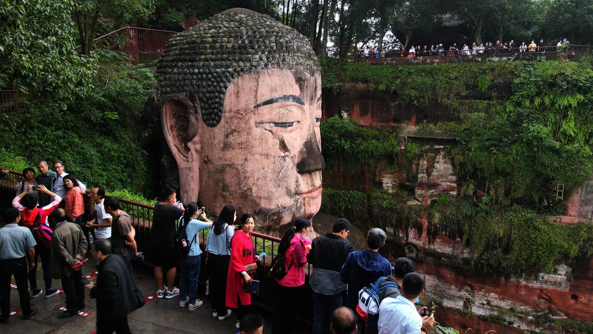 Tourists visit the Leshan Giant Buddha, a UNESCO World Heritage Site, on the first day of the eight-day National Day holiday on October 1. (Liu Zhongjun/China News Service via Getty Images)