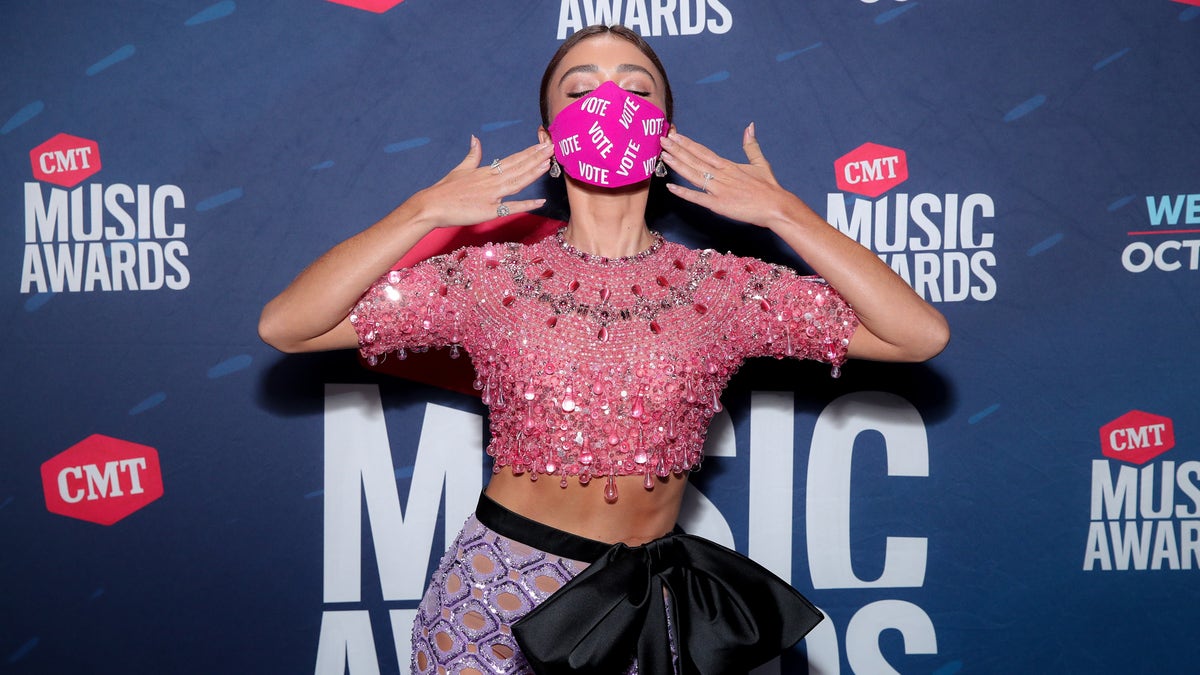Sarah Hyland wears a mask with the word 'VOTE' written on it multiple times. (Photo by Rich Fury/CMT2020/Getty Images for CMT)