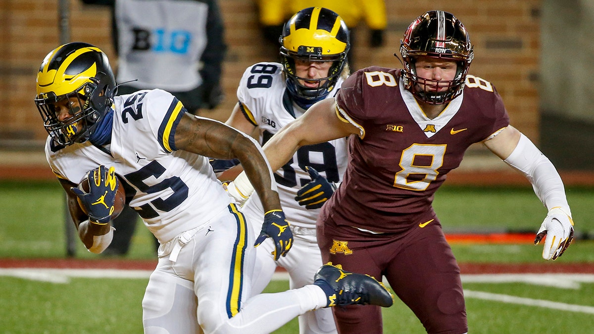 Michigan running back Hassan Haskins (25) rushes past tight end Carter Selzer (89) and Thomas Rush (8) for a touchdown in the second quarter of an NCAA college football game Saturday, Oct. 24, 2020, in Minneapolis. (AP Photo/Bruce Kluckhohn)