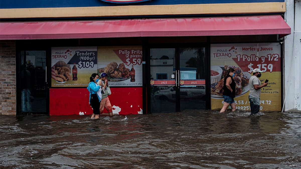 08 October 2020, Mexico, Merida: People walk along a road that was flooded by the heavy rains of hurricane "Delta". "Delta" has gained strength as it heads towards the United States. Photo: Jacky Muniello/dpa (Photo by Jacky Muniello/picture alliance via Getty Images)