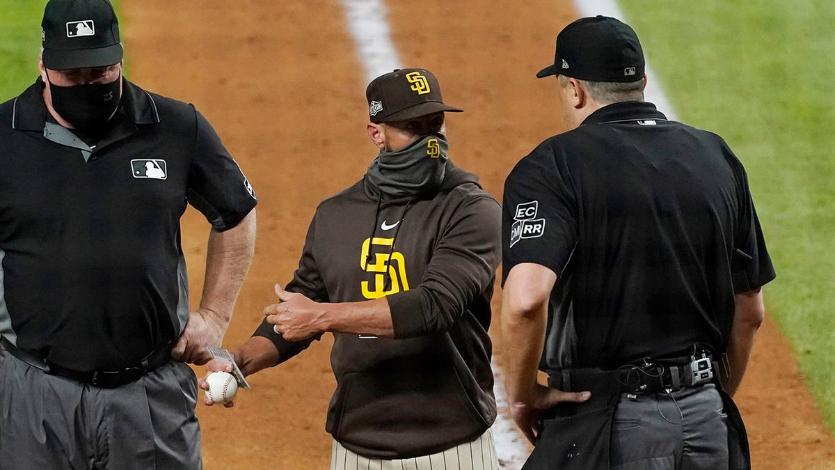 San Diego Padres manager Jayce Tingler, center, argues with home plate umpire Lance Barrett, right, during the sixth inning in Game 1 of a baseball NL Division Series against the Los Angeles Dodgers, Tuesday, Oct. 6, 2020, in Arlington, Texas.