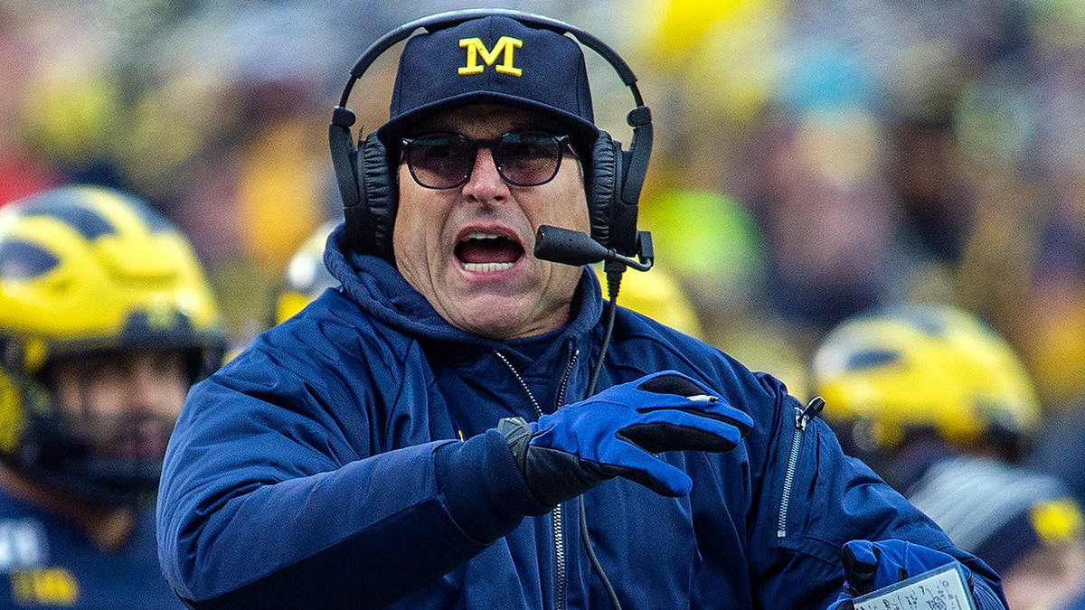 FILE  - In this Nov. 30, 2019, file photo, Michigan head coach Jim Harbaugh calls a timeout in the third quarter of an NCAA college football game against Ohio State in Ann Arbor, Mich.
