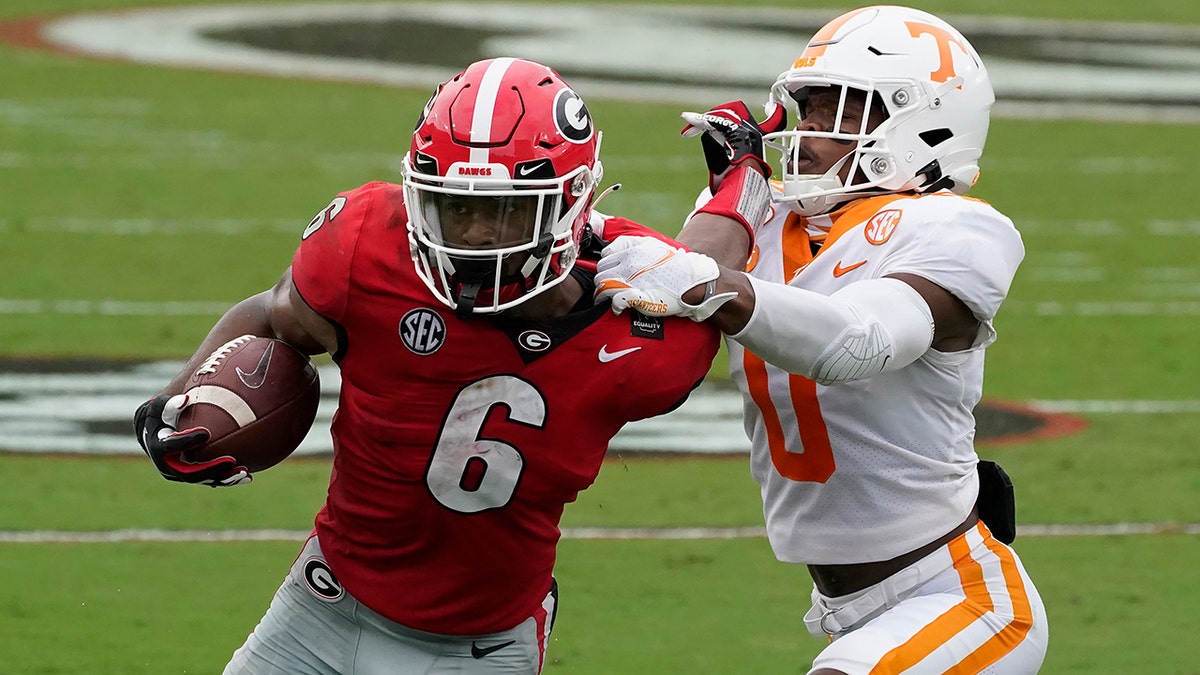 Georgia running back Kenny McIntosh (6) tries to fend off Tennessee defensive back Bryce Thompson (0) in the first half of an NCAA college football game Saturday, Oct. 10, 2020, in Athens, Ga. (AP Photo/John Bazemore)