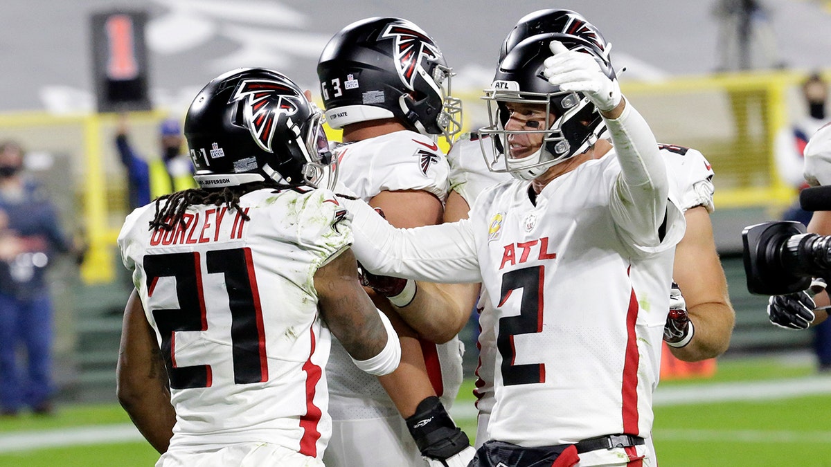 Atlanta Falcons' Todd Gurley (21) celebrates a touchdown run with quarterback Matt Ryan (2) during the second half of an NFL football game against the Green Bay Packers, Monday, Oct. 5, 2020, in Green Bay, Wis. (AP Photo/Mike Roemer)