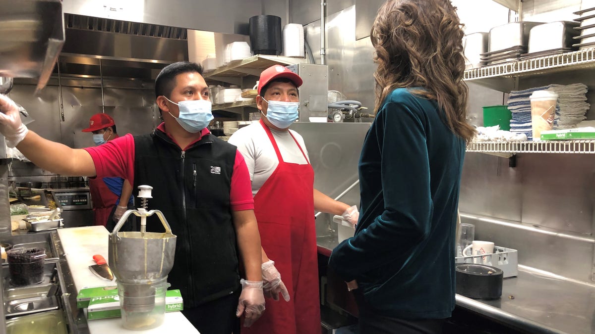 South Dakota Gov. Kristi Noem speaks with the kitchen staff during a stop at the famed Red Arrow Diner in Manchester, New Hampshire on Oct. 15, 2020