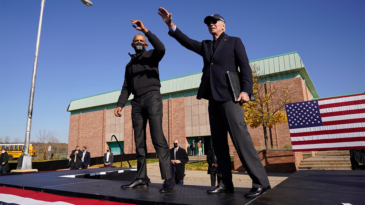 Democratic presidential candidate former Vice President Joe Biden, right, and former President Barack Obama wave to the audience at a rally at Northwestern High School in Flint, Mich., Saturday, Oct. 31, 2020. (AP Photo/Andrew Harnik)