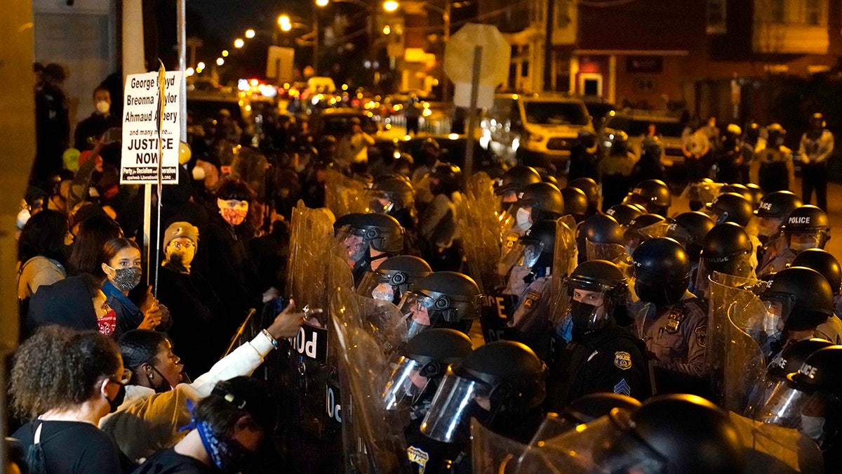 Protesters confront police during a march, Tuesday, Oct. 27, 2020, in Philadelphia. Hundreds of demonstrators marched in West Philadelphia over the death of Walter Wallace Jr., a Black man who was killed by police in Philadelphia on Monday. Police shot and killed the 27-year-old on a Philadelphia street after yelling at him to drop his knife. (AP Photo/Matt Slocum)