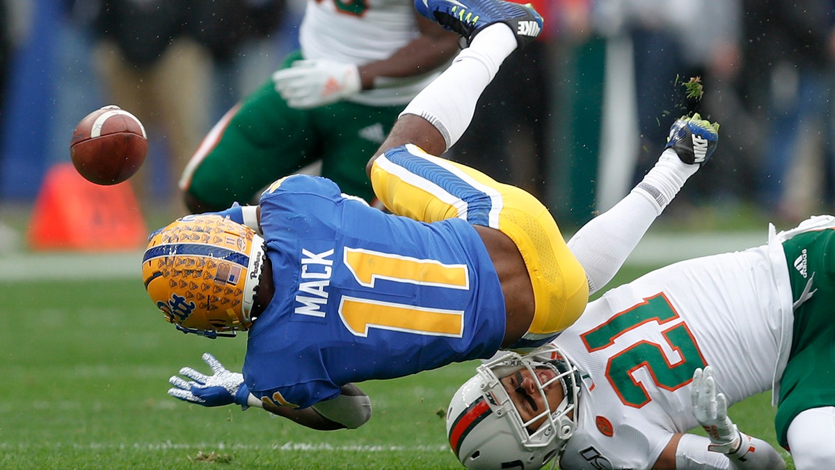 FILE - In this Saturday, Oct. 26, 2019, file photo, Pittsburgh wide receiver Taysir Mack (11) fumbles the ball after getting hit by Miami's Bubba Bolden (21) during the first half of an NCAA college football game, in Pittsburgh. (AP Photo/Keith Srakocic, File)