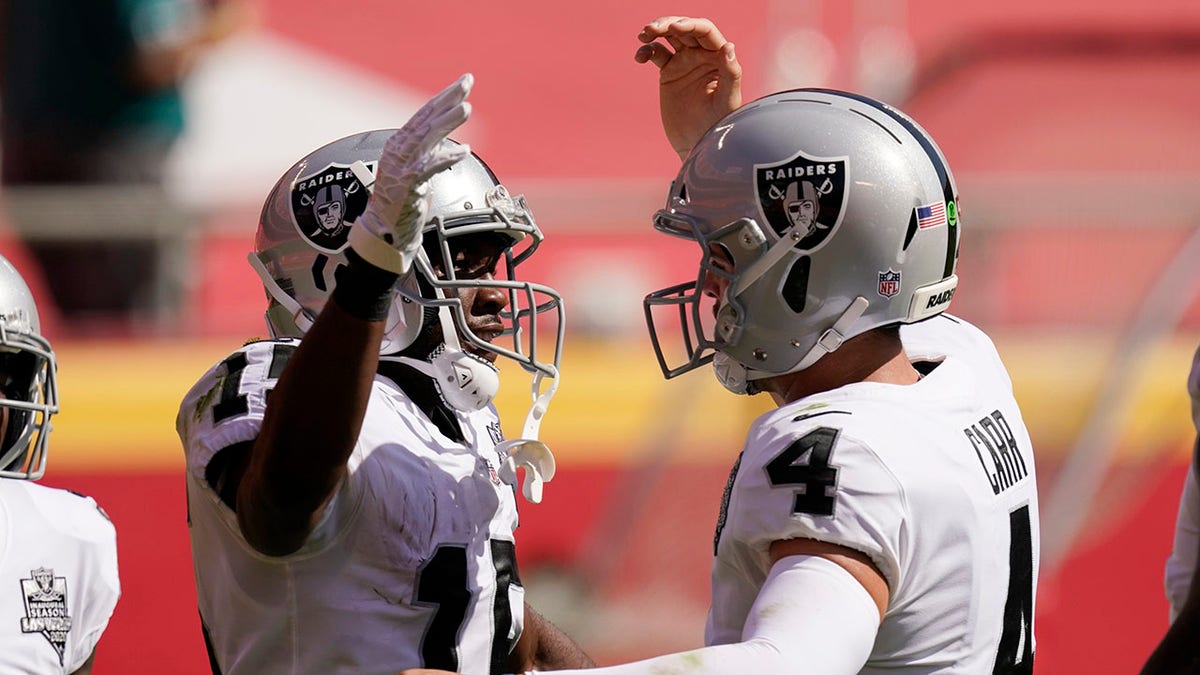 Las Vegas Raiders wide receiver Nelson Agholor, left, celebrates with quarterback Derek Carr after catching a 59-yard touchdown pass during the first half of an NFL football game against the Kansas City Chiefs, Sunday, Oct. 11, 2020, in Kansas City. (AP Photo/Charlie Riedel)