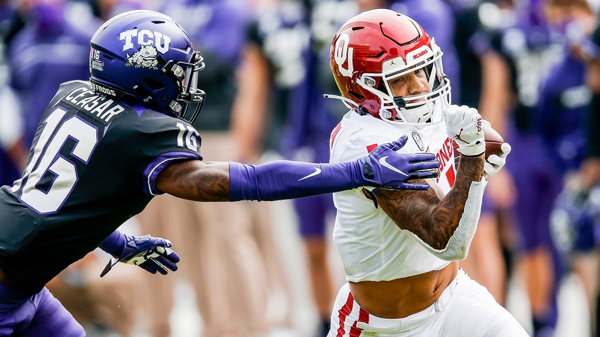 Oklahoma running back Seth McGowan (1) carries the ball as TCU cornerback C.J. Ceasar II (16) defends during the second half of an NCAA college football game, Saturday, Oct. 24, 2020, in Fort Worth, Texas. Oklahoma won 33-14. (AP Photo/Brandon Wade)