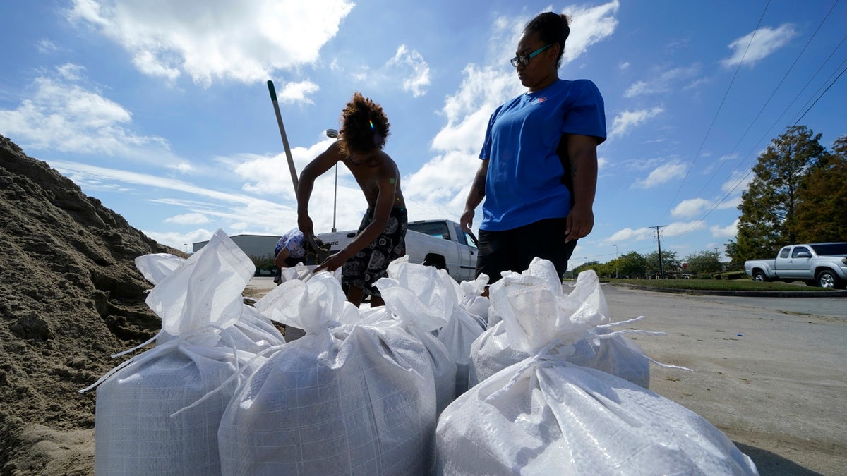 Stephanie Verrett and Jodie Jones fill sandbags to protect their home in anticipation of Hurricane Delta, expected to arrive along the Gulf Coast later this week, in Houma, La., Wednesday, Oct. 7, 2020.