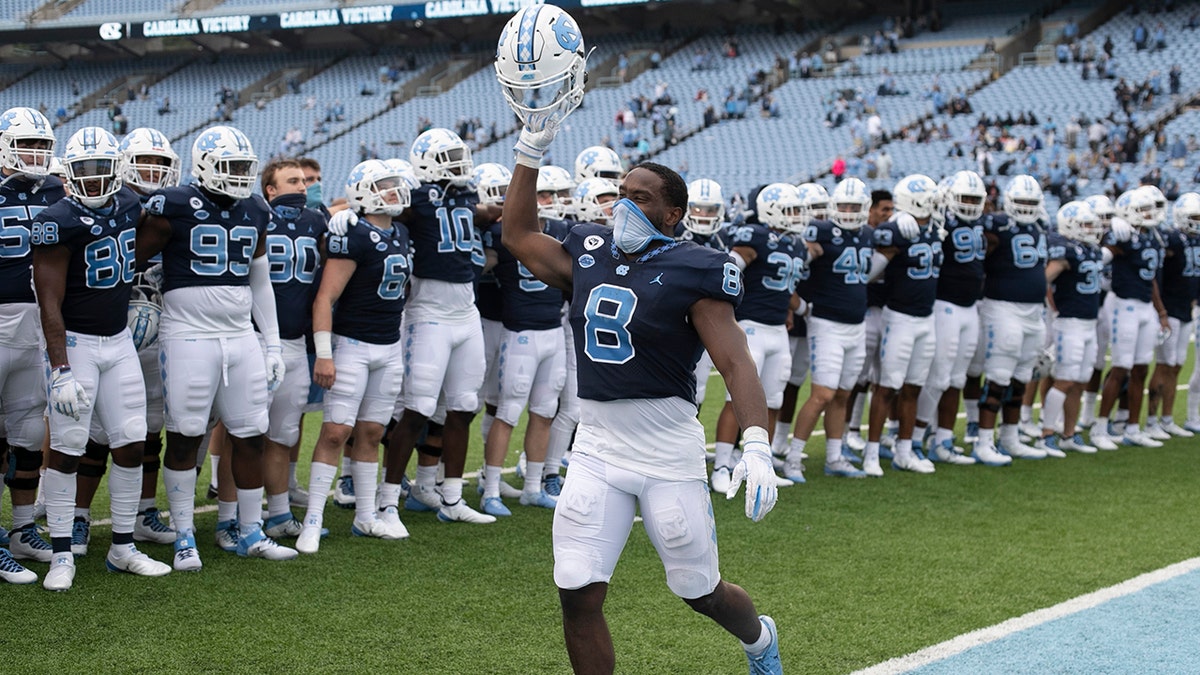 North Carolina's Michael Carter (8) leads the celebration following the Tar Heels' 56-49 victory over Virginia Tech in an NCAA college football game, Saturday, Oct. 10, 2020 at Kenan Stadium in Chapel Hill, N.C. (Robert Willett/The News &amp; Observer via AP)