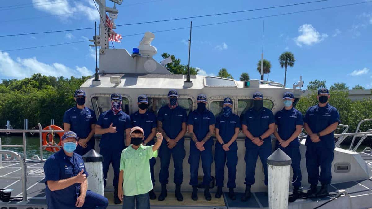 Avani Perez, 11, shows off a gold coin given to for his actions in the rescue of his grandparents at sea. (U.S. Coast Guard)