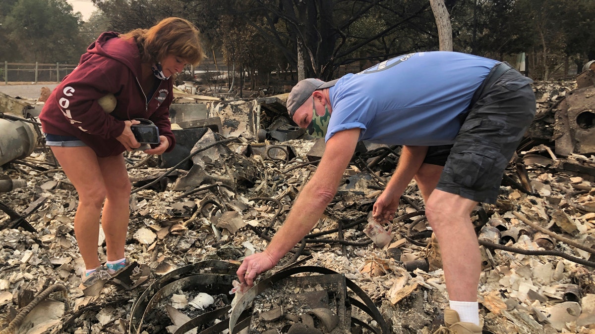 Kevin Conant and his wife, Nikki, sift through the debris of their burnt home and business "Conants Wine Barrel Creations," after the Glass/Shady fire completely engulfed it, Wednesday, Sept. 30, 2020, in Santa Rosa, Calif.