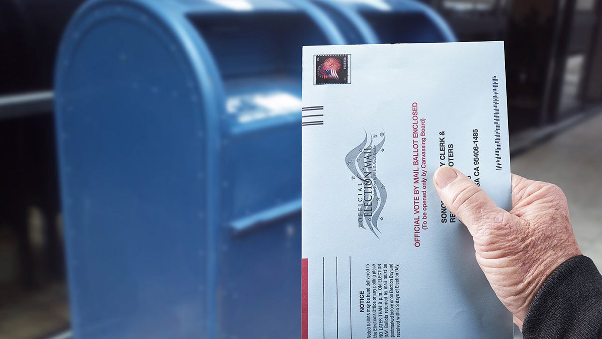 Gualala, CA, July 4, 2020 - Person mailing United States absentee ballot for voting in an election by mail.