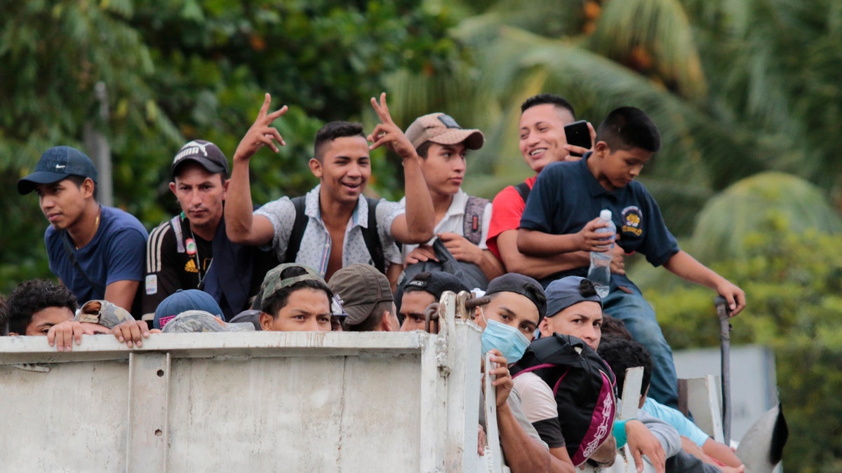 Migrants get a free ride from a trucker toward the Guatemalan border after leaving San Pedro Sula, Honduras. (AP)