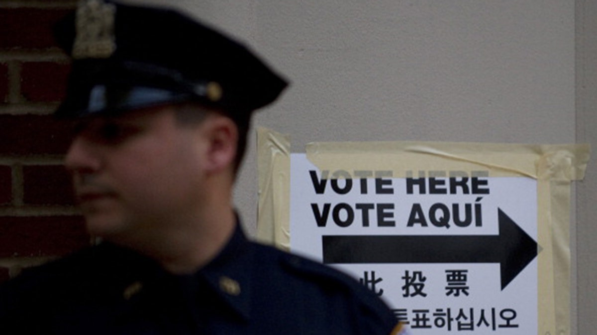 A New York City police officer stands guard outside a polling station in a public school Nov. 2, 2010 in New York.  (DON EMMERT/AFP via Getty Images)