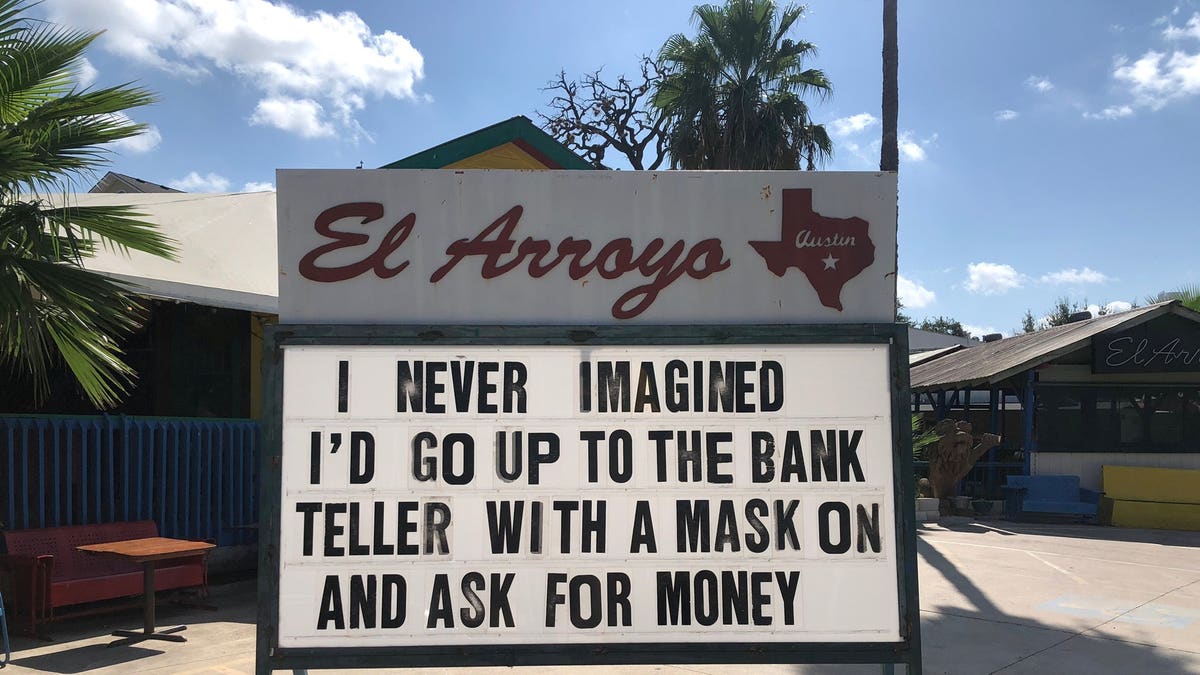 "I never imagined I'd go to the bank teller with a mask on and ask for money,” one sign teased. ?