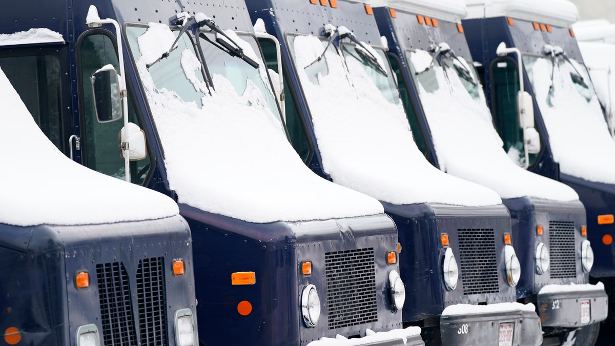 Snow covers the windshields of delivery vans parked outside a dairy after an autumn snowstorm swept over the intermountain West, Monday, Oct. 26, 2020, in Denver.