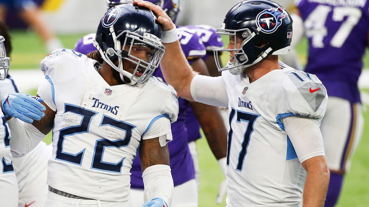 Tennessee Titans running back Derrick Henry (22) celebrates with teammate Ryan Tannehill, right, after scoring on a 1-yard touchdown run during the second half of an NFL football game against the Minnesota Vikings, Sunday, Sept. 27, 2020, in Minneapolis. (AP Photo/Bruce Kluckhohn)