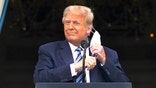 President Donald Trump removes his face mask to speak from the Blue Room Balcony of the White House to a crowd of supporters, Saturday, Oct. 10, 2020, in Washington. (AP Photo/Alex Brandon)