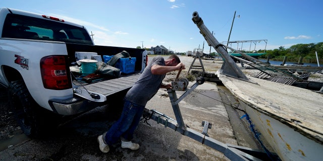 Charles Russ pulls their boat from the water after pulling his crab traps from Bayou Dularge in anticipation of Hurricane Delta, expected to arrive along the Gulf Coast later this week, in Theriot, La., Wednesday, Oct. 7, 2020.