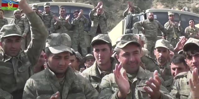 In this grab taken from video released by Azerbaijan's Defense Ministry on Saturday, Oct. 3, 2020, Azerbaijan's solders applaud at a meeting with officers during fighting with forces of the self-proclaimed Republic of Nagorno-Karabakh, Azerbaijan. Armenia and Azerbaijan on Saturday said heavy fighting is continuing in their conflict over the separatist territory of Nagorno-Karabakh. Azerbaijan's president criticized the international mediators who have tried for decades to resolve the dispute. (Azerbaijan's Defense Ministry via AP)